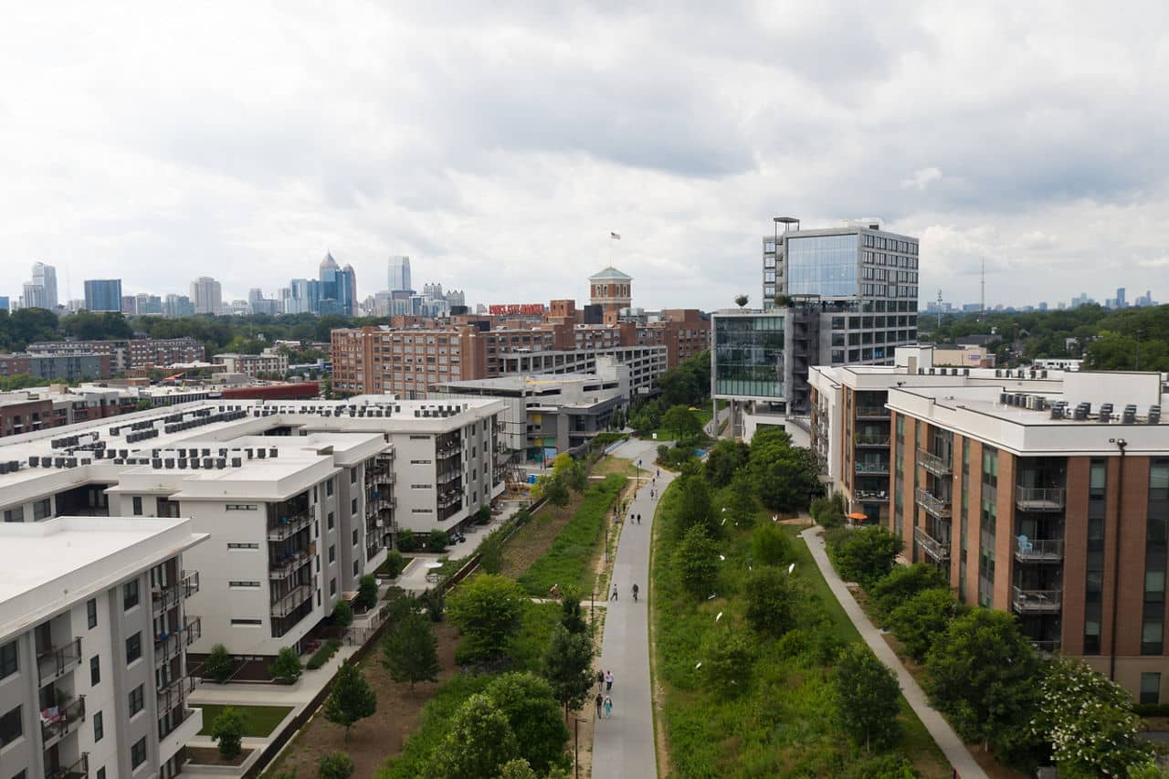 Aerial view of the Atlanta BeltLine in Old Fourth Ward, GA with modern apartment buildings and the downtown skyline.